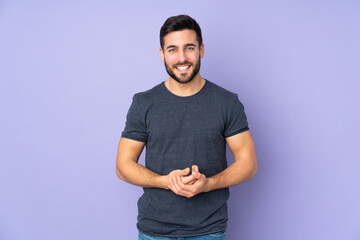 Caucasian handsome man laughing over isolated purple background