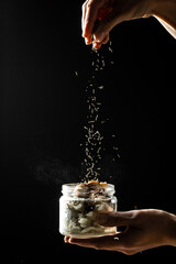 Cheesemaker showing the proceeding to make cheese , Chef hands adding seasoning in Jar with cheese...