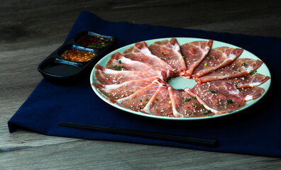 fresh raw pork, meat ,beef, belly, sliced on square dish disk plate  on fabric and wood, wooden background, shabu, hot pot ingredients.