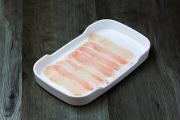 fresh raw pork, meat ,beef, belly, sliced on square plate  on wood, wooden background,set shabu, hot pot ingredients.