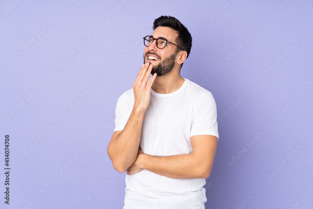 Poster Caucasian handsome man over isolated background looking up while smiling