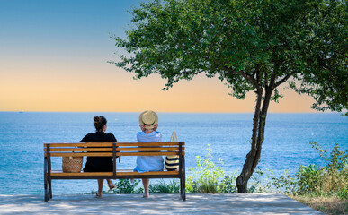 girls on a bench against the sea