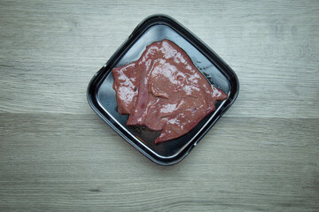 fresh raw liver,pork, meat ,beef, belly, sliced on square plate  on wood, wooden background,set shabu, hot pot ingredients.