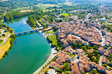 View from drone of cityscape of small French town of Cazeres on river Garonne in summer - obrazy, fototapety, plakaty