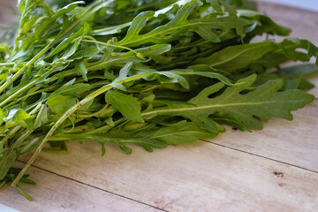 Green dill leaves and arugula on a wooden background