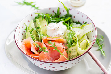 Ketogenic, keto diet. Salted salmon, avocado and cucumber salad with cream cheese in white bowl. Healthy food.