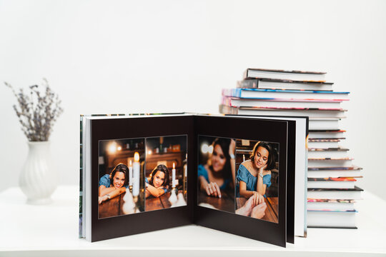 stack of books. open photobook from photo shoots of beautiful brunette woman 