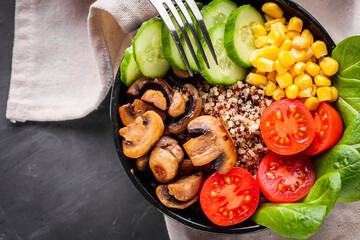 bowl of healthy quinoa with vegetables on a dark rustic background