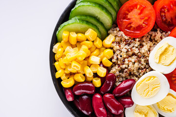 bowl of healthy quinoa with vegetables on a white background