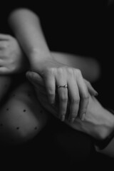 Man and woman holding hands. Marriage proposal. Engagement ring. No face. Photo close up. Black and white photo. The photo is vertical.