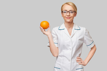 nutritionist doctor healthy lifestyle concept - holding orange fruit