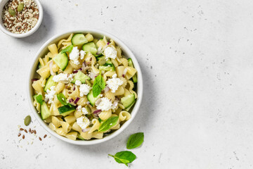 Spring light vegan  cucumber feta pasta salad. Space for text, top view.