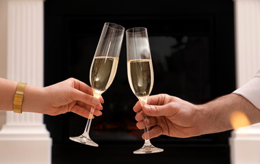 People clinking glasses with champagne at home, closeup