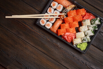 sushi rolls with seafood on a wooden table and chopsticks