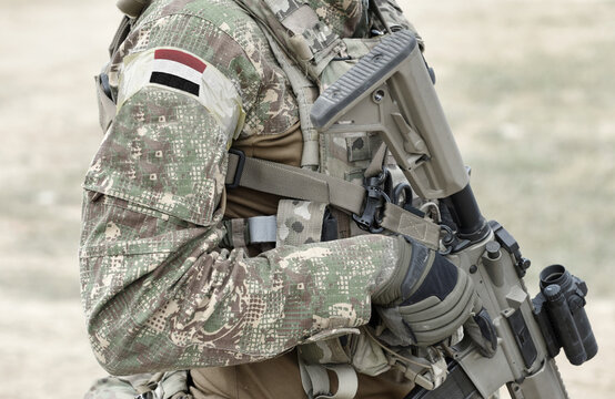 Soldier with assault rifle and flag of Yemen on military uniform. Collage.