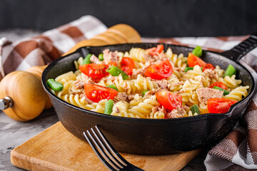 delicious traditional Italian pasta with tuna on a dark rustic stone background