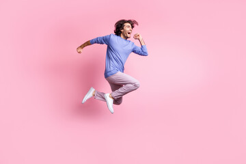 Fototapeta na wymiar Full size photo of young attractive smiling cheerful excited positive man jump fly run isolated on pink color background