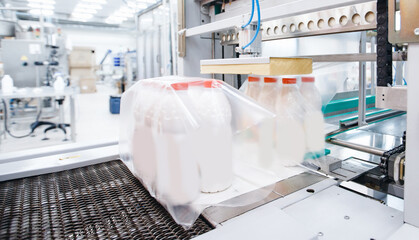 Dairy factory industry, automatic packaging of bottles with milk in plastic bags