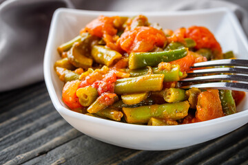 stewed green beans on a dark wooden rustic background