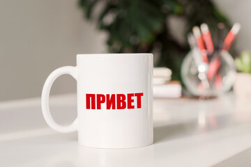 The word Hello on russian language written on white coffee cup