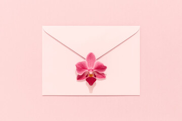 Orchid flower on pink envelope. Congratulation card, Womens Day, Mothers Day, Valentines, birthday.