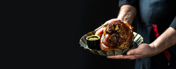 Roasted pork knuckle eisbein with sauerkraut, mustard and rosemary. Oktoberfest, traditional German...