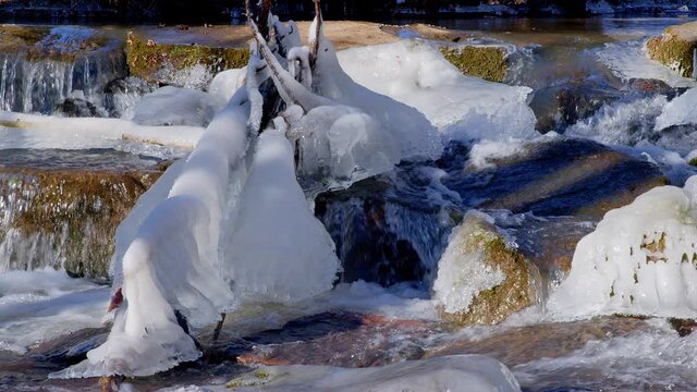 frozen stream with icicles in winter 4k