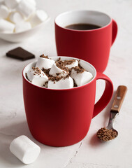 Hot chocolate with marshmallows in a red cup.