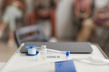Background image of covid vaccine set and coronavirus test on desk in clinic, copy space
