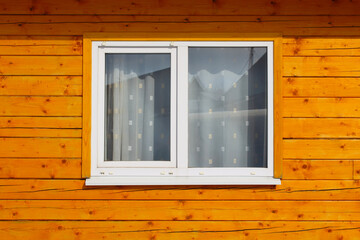 White glass plastic window in a wooden house. Double-glazed window. Close-up. Background. Texture.