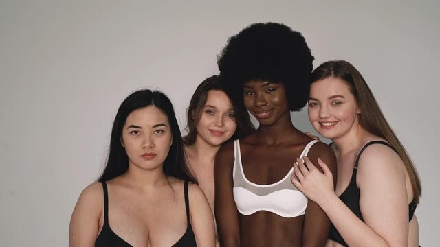 Four beautiful women wearing lingerie smiling at camera