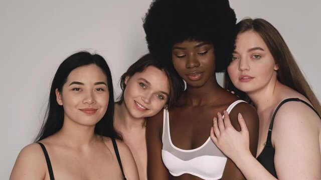 Four beautiful women standing toghether, smiling and hugging