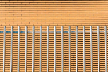 Shiny parallel metal bars, tall and sturdy, form a security fence.