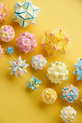 Set of multicolor handmade modular origami balls or Kusudama Isolated on yellow background. Visual...
