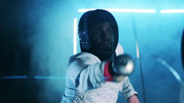 Male fencer is attacking his opponent. Active athlete, concentration concept.
