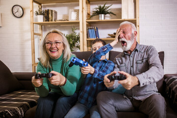 Happy grandparents playing video games with their grandson