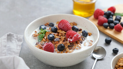 Granola bowl with fresh blueberries, raspberries and almond milk. Healthy breakfast food or snack