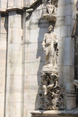 Detail of a sculpture carved on white marble on the facade of the Cathedral of Milan (Italy)