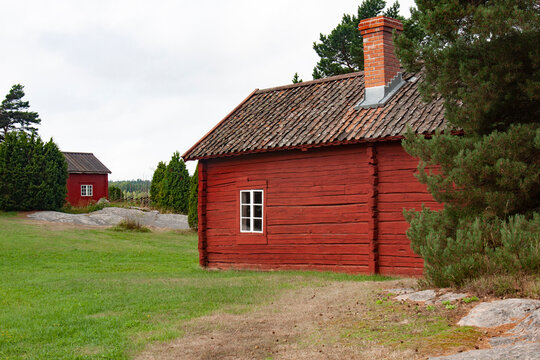 Typical Red Cottages On Aland Islands, Finland. Wooden Huts On Rocky Islands In The Middle Of Nature