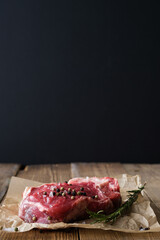 Raw meat on wooden board with dark background