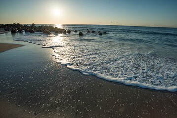 朝日が照らす海の波打ち際
