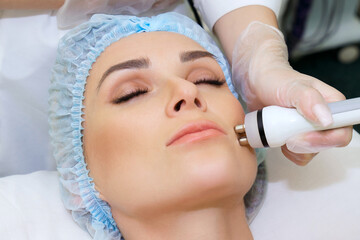 RF lifting procedure on the face of a young woman in a spa salon. Radiofrequency lifting to correct the shape of a young woman's face.