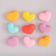 Creative food concept with heart shaped macaroons on grey background. Flat lay design