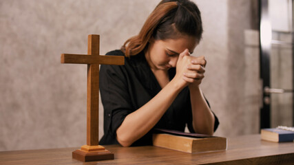 Obraz premium A young Asian Christian woman praying to Jesus Christ in a church.