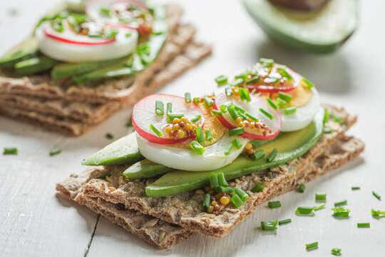 Fresh and healthy sandwich with avocado, radish and eggs
