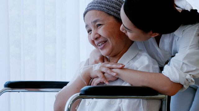 daughter encourages and comforts a mother with cancer during hospitalization.