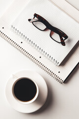 Office desk table with supplies, coffee cup and flower. Top view