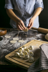 Fototapeta na wymiar Dumplings on the table against the background of a woman cook 