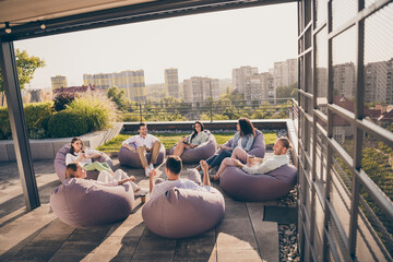 Photo of group agents sitting beanbag thinking startup marketing strategy outdoors outside workshop...