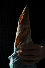 Traditional French bread baguette hold by man's hand